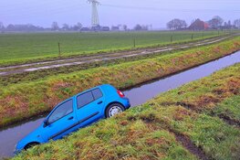 Automobilist raakt van de weg op modderig wegdek in Berkhout