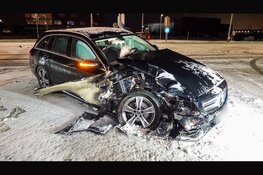 Automobilist ramt paal op besneeuwd wegdek bij Avenhorn