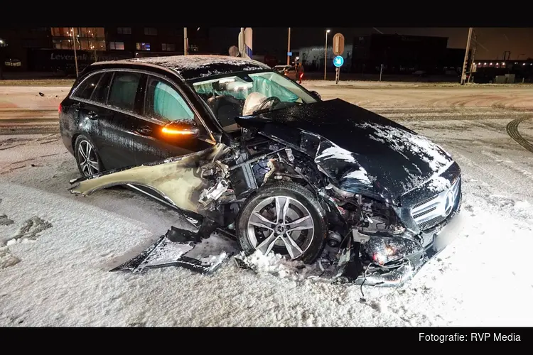 Automobilist ramt paal op besneeuwd wegdek bij Avenhorn